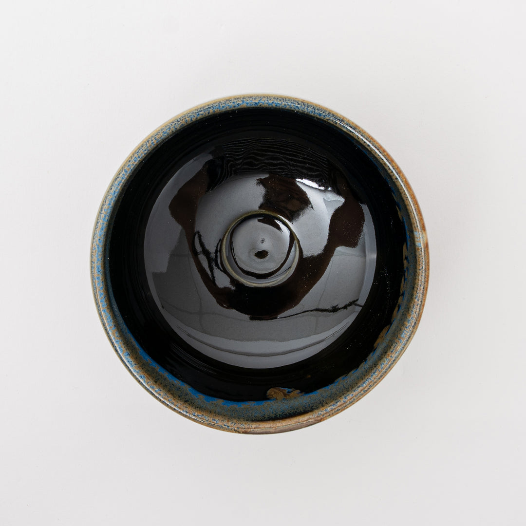 A top-down view of the handcrafted matcha bowl, showing its wide base and shiny black interior.