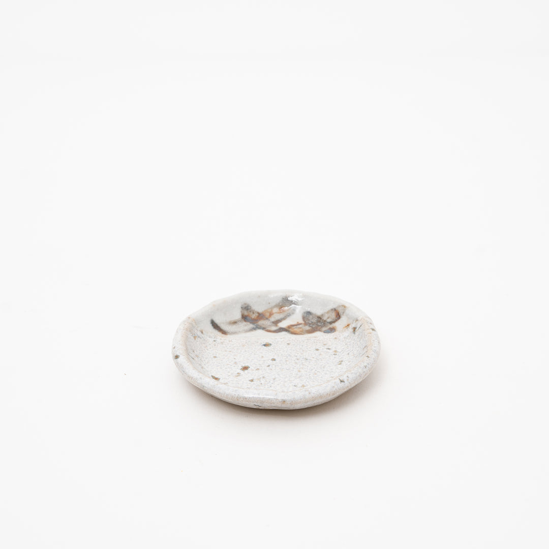 Japanese Shino style small ceramic plate in creamy white with hand-brushed brown and grey glazes, approx 9cm diameter