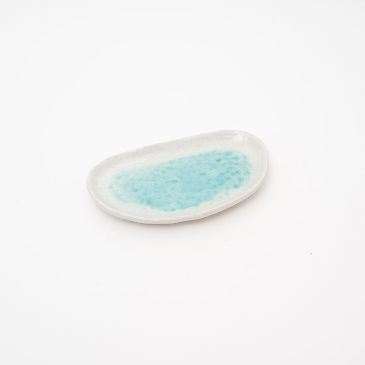 A handcrafted Seto ware dish on a white background, showcasing its oval shape and vibrant turquoise center. The rustic stoneware texture makes it ideal for restaurant plating.