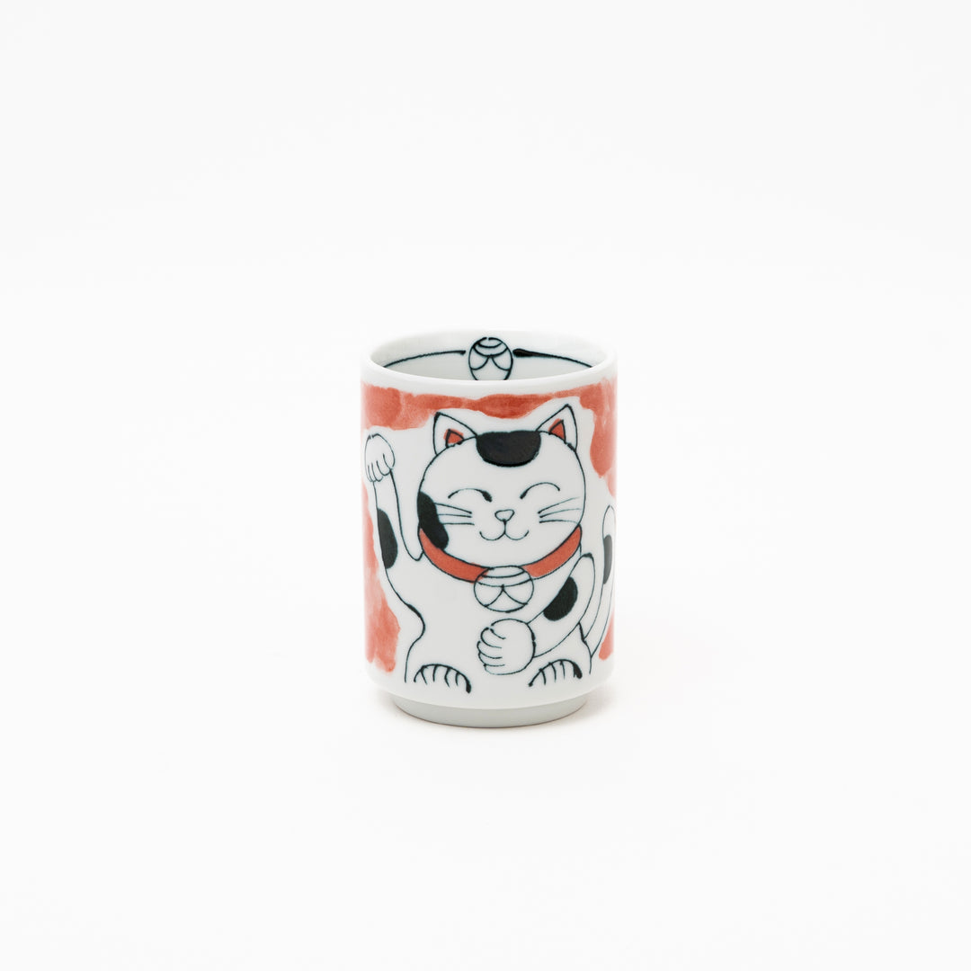 Front view of an authentic Japanese Maneki-Neko lucky cat porcelain cup with a hand-painted white cat, red collar, and red background wash.
