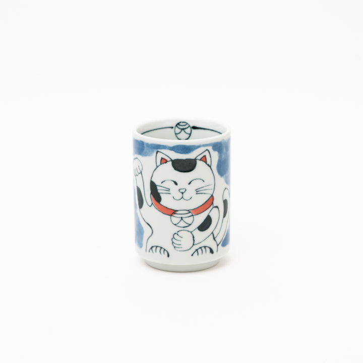 Front view of an authentic Japanese Maneki-Neko lucky cat porcelain cup with a hand-painted white cat, red collar, and blue background wash.