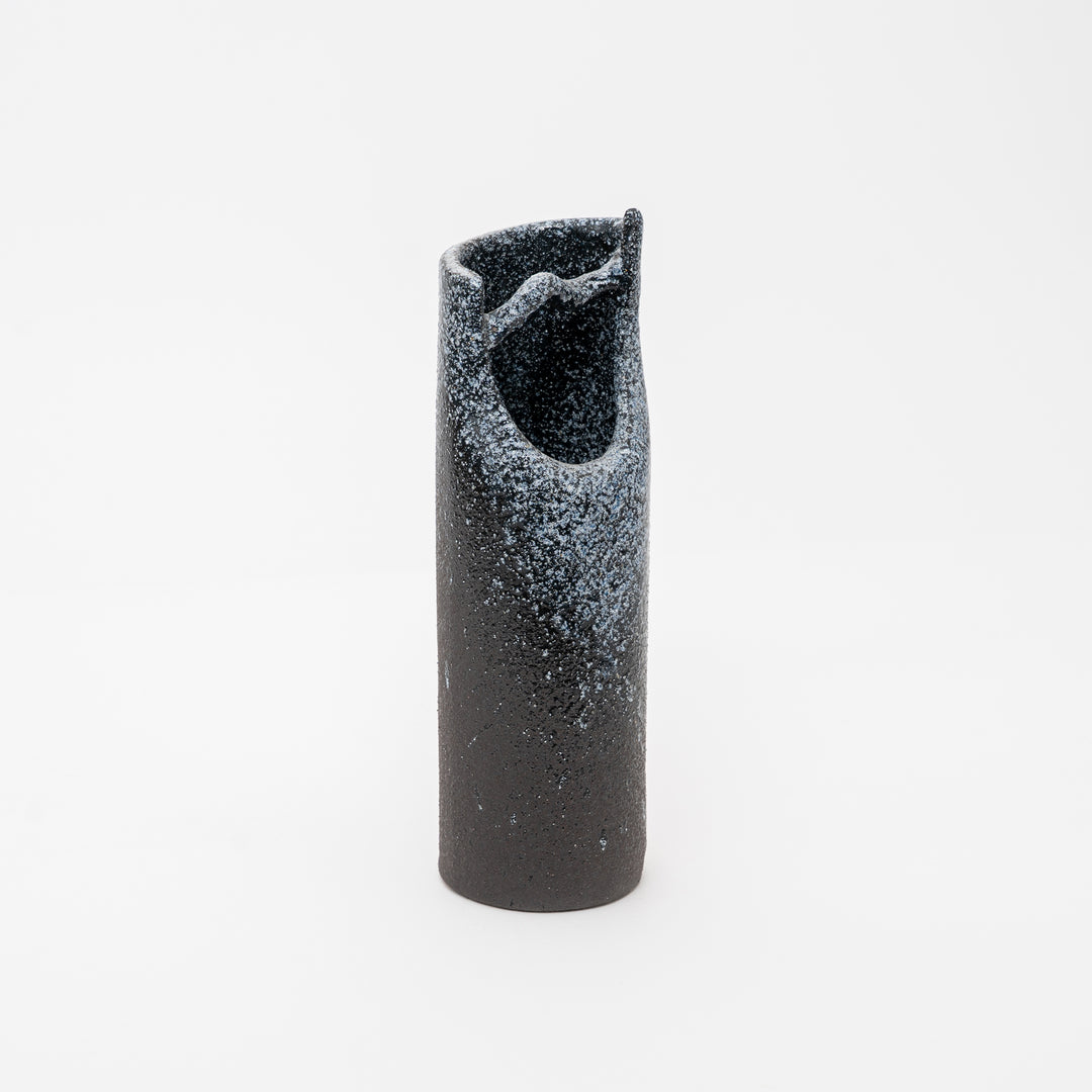 Black cylindrical object with textured surface on a white background