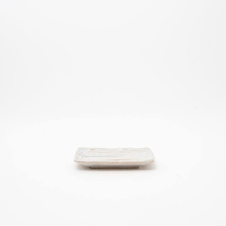 Japanese rectangular ceramic plate with hand-textured wave pattern surface in cream white glaze