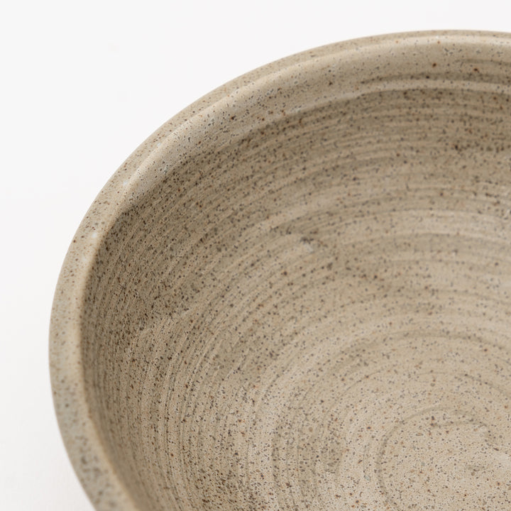 Close-up of the textured, earthy ceramics inside the bowl