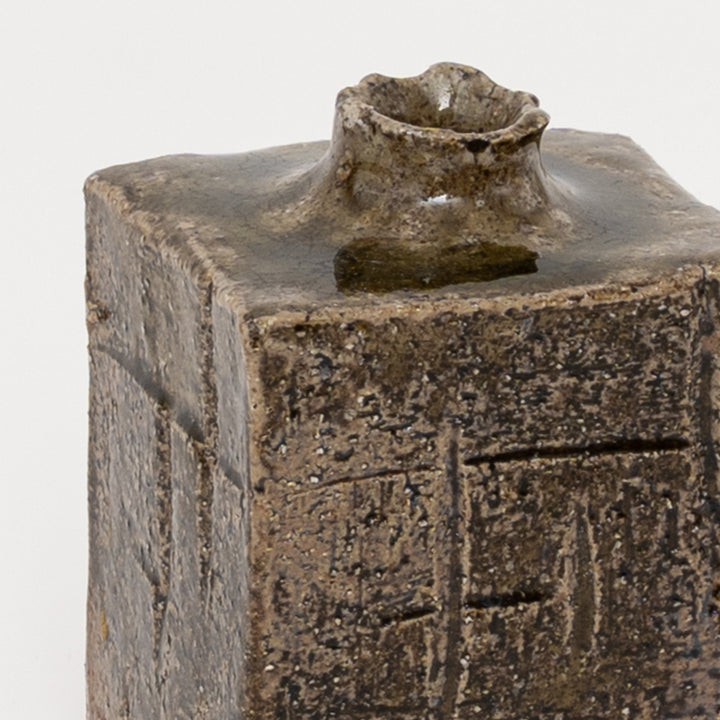 Close-up of carved geometric texture on dark Shigaraki mini vase