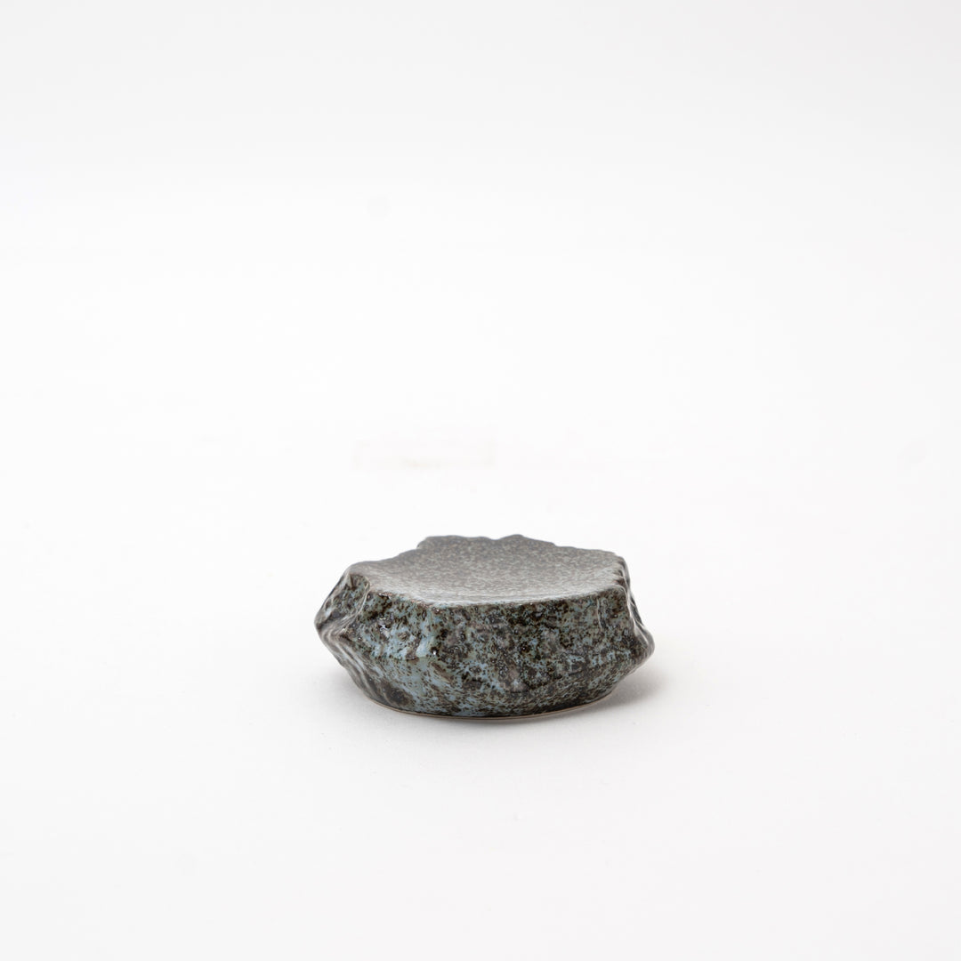 Side view of a Mikage stone-style ceramic dish, highlighting its irregular, textured shape and unique surface.