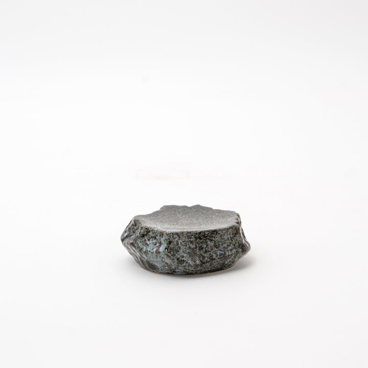 Side view of a Mikage stone-style ceramic dish, highlighting its irregular, textured shape and unique surface.