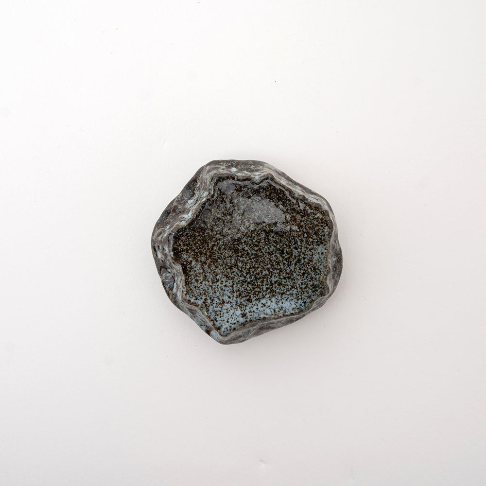 Small handcrafted Mikage stone-style ceramic plate with a dark, speckled glaze and a rugged, natural-looking edge.