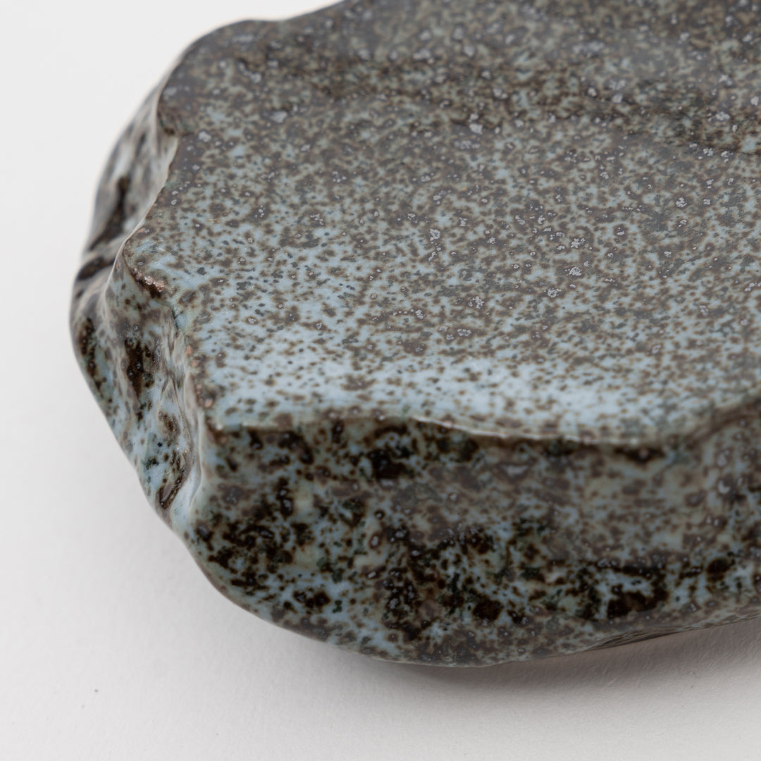 Top-down view of a small Mikage stone-style plate, showing the speckled dark and light blue glaze