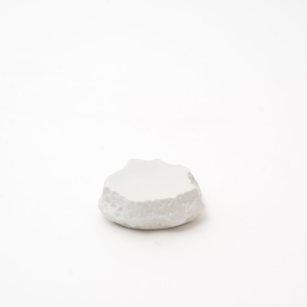 Small handcrafted white Mikage stone-style ceramic plate with a dark, speckled glaze and a rugged, natural-looking edge