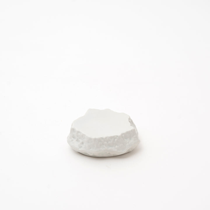 Small handcrafted white Mikage stone-style ceramic plate with a dark, speckled glaze and a rugged, natural-looking edge