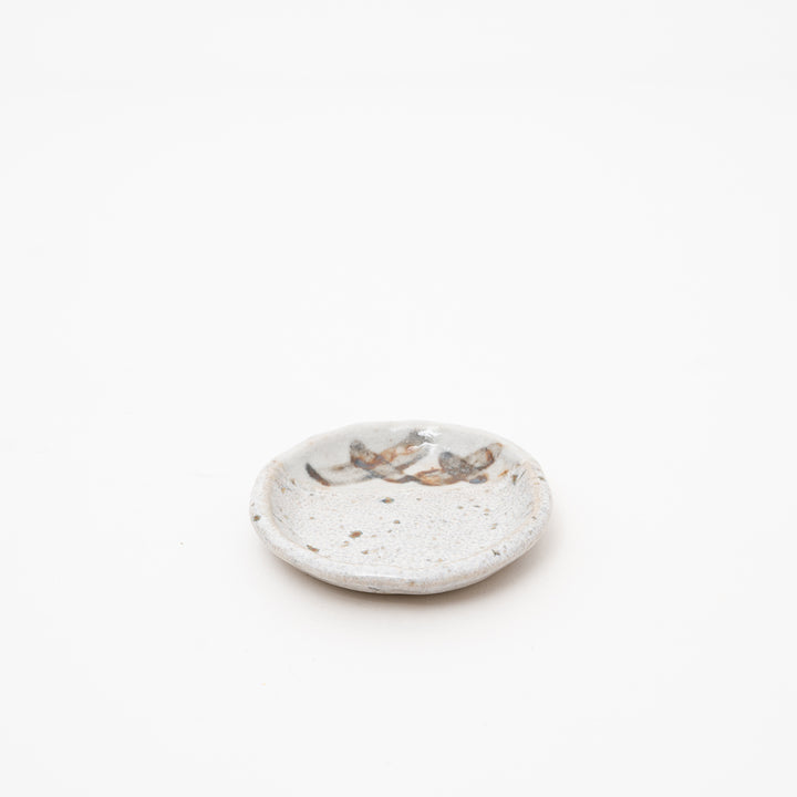 Japanese Shino style small ceramic plate in creamy white with hand-brushed brown and grey glazes, approx 9cm diameter