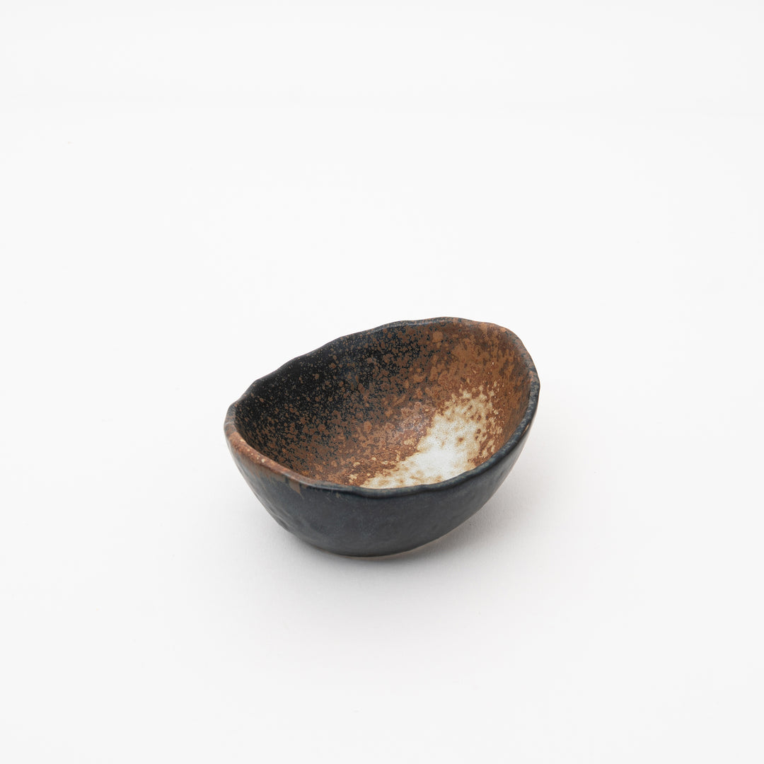 Handmade Japanese Seto ware small bowl, featuring a unique black Bizen style with a dark exterior and distressed brown glaze, side view.
