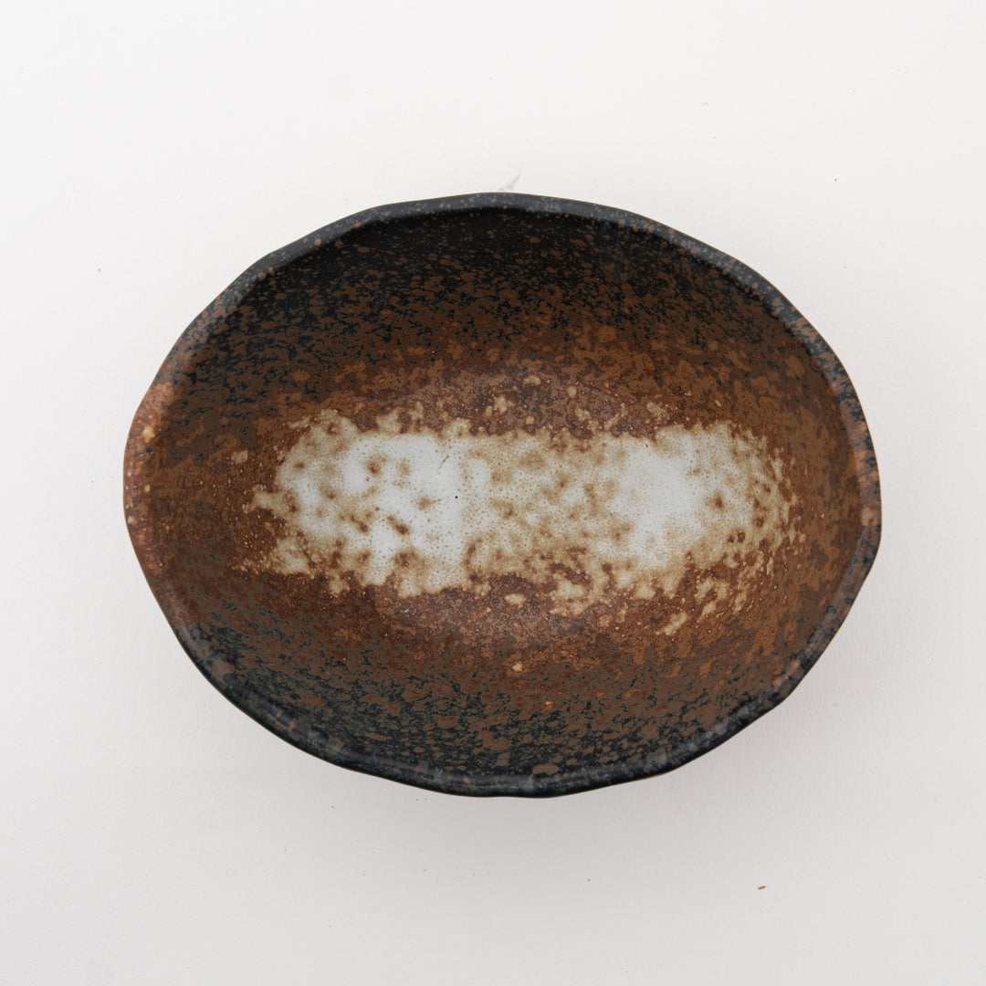 Overhead view of the handmade Japanese bowl, highlighting the interior's speckled off-white and brown glaze against the dark, Bizen style rim.