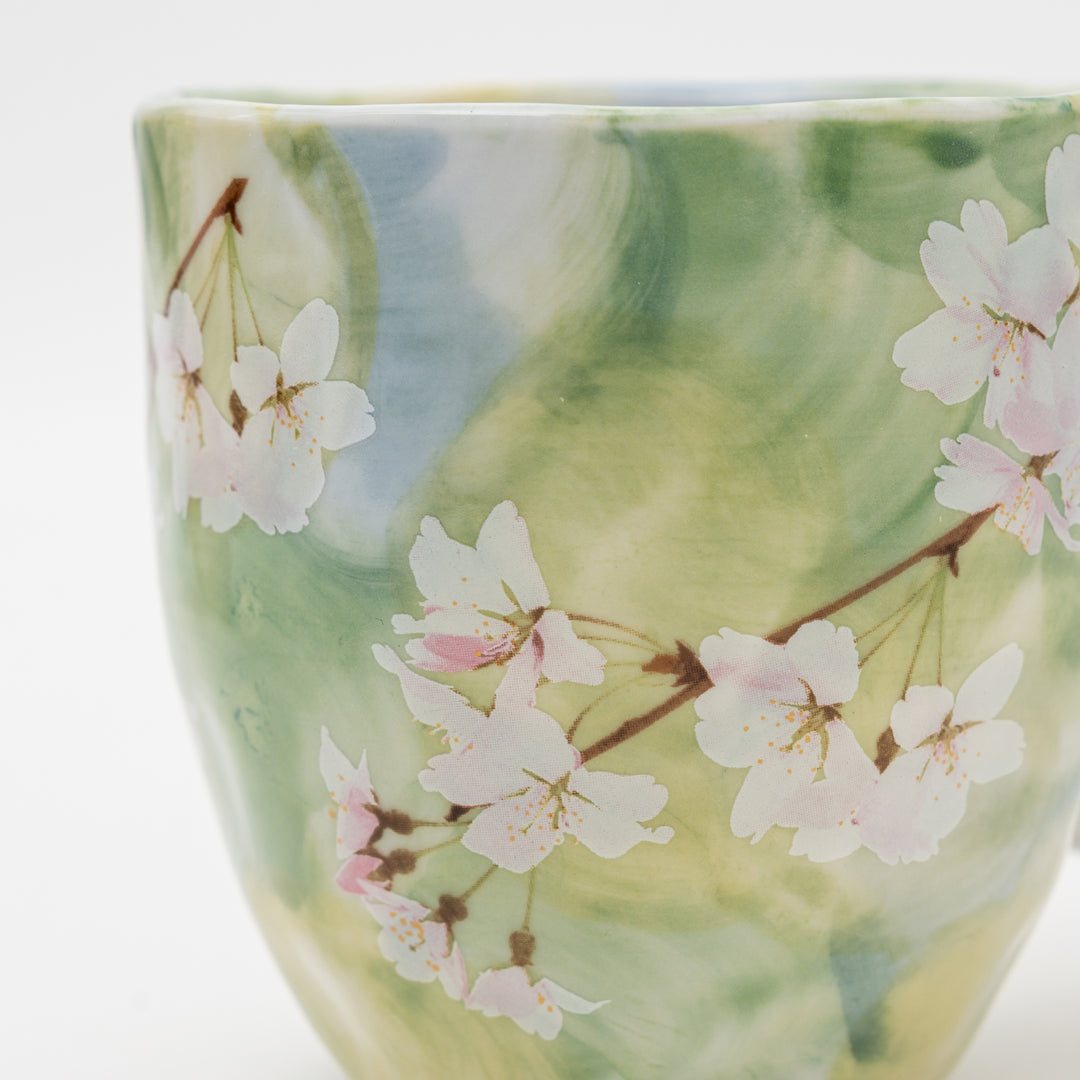 A close-up shot of the Japanese cherry blossom mug showing the intricate sakura design and watercolor details.