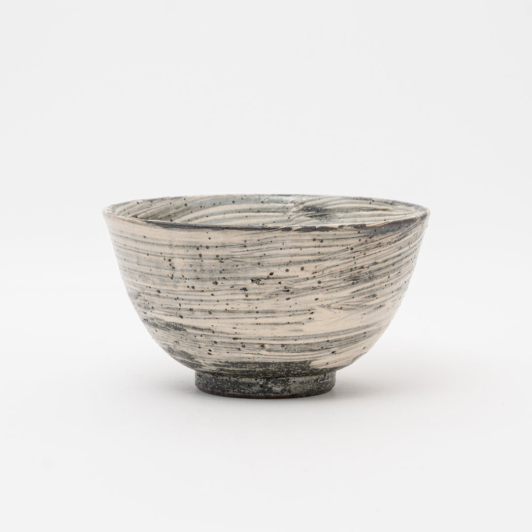  A side profile of a handmade Japanese ceramic bowl, highlighting the rustic texture and horizontal Hakeme lines characteristic of Shigaraki Yaki stoneware.