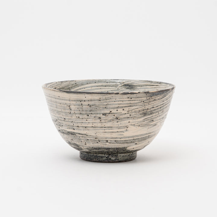  A side profile of a handmade Japanese ceramic bowl, highlighting the rustic texture and horizontal Hakeme lines characteristic of Shigaraki Yaki stoneware.