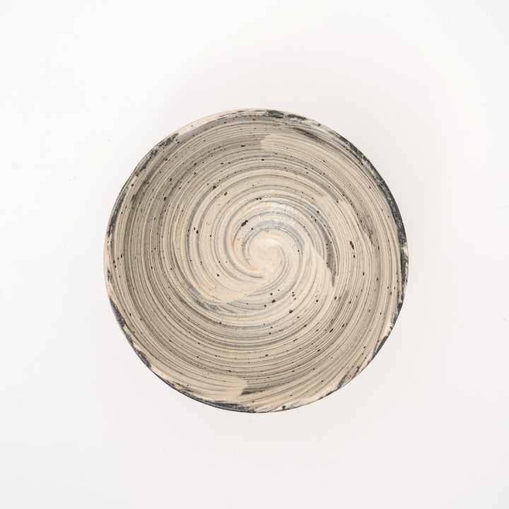 An overhead view of an authentic Shigaraki Yaki bowl, showing the unique spiral pattern and speckled glaze, with a visible Hakeme brushstroke texture.