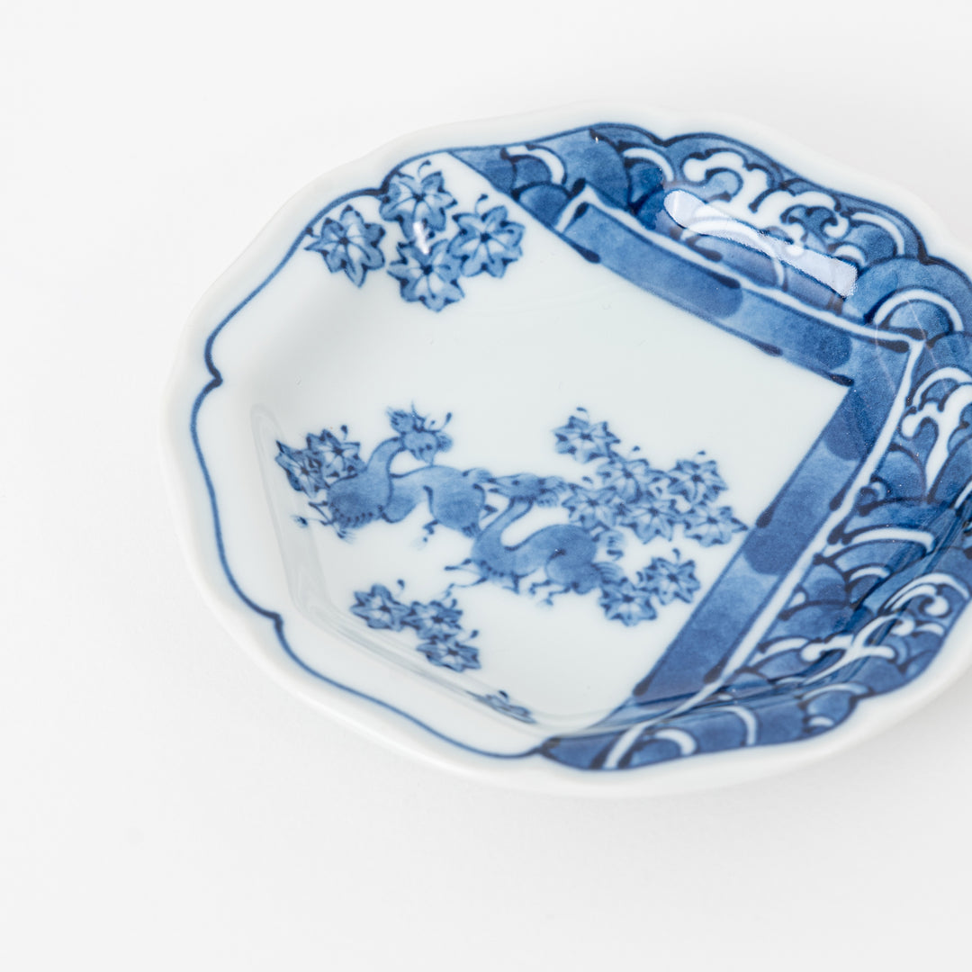 Detail of Japanese porcelain dipping dish showing traditional blue and white landscape and floral patterns.