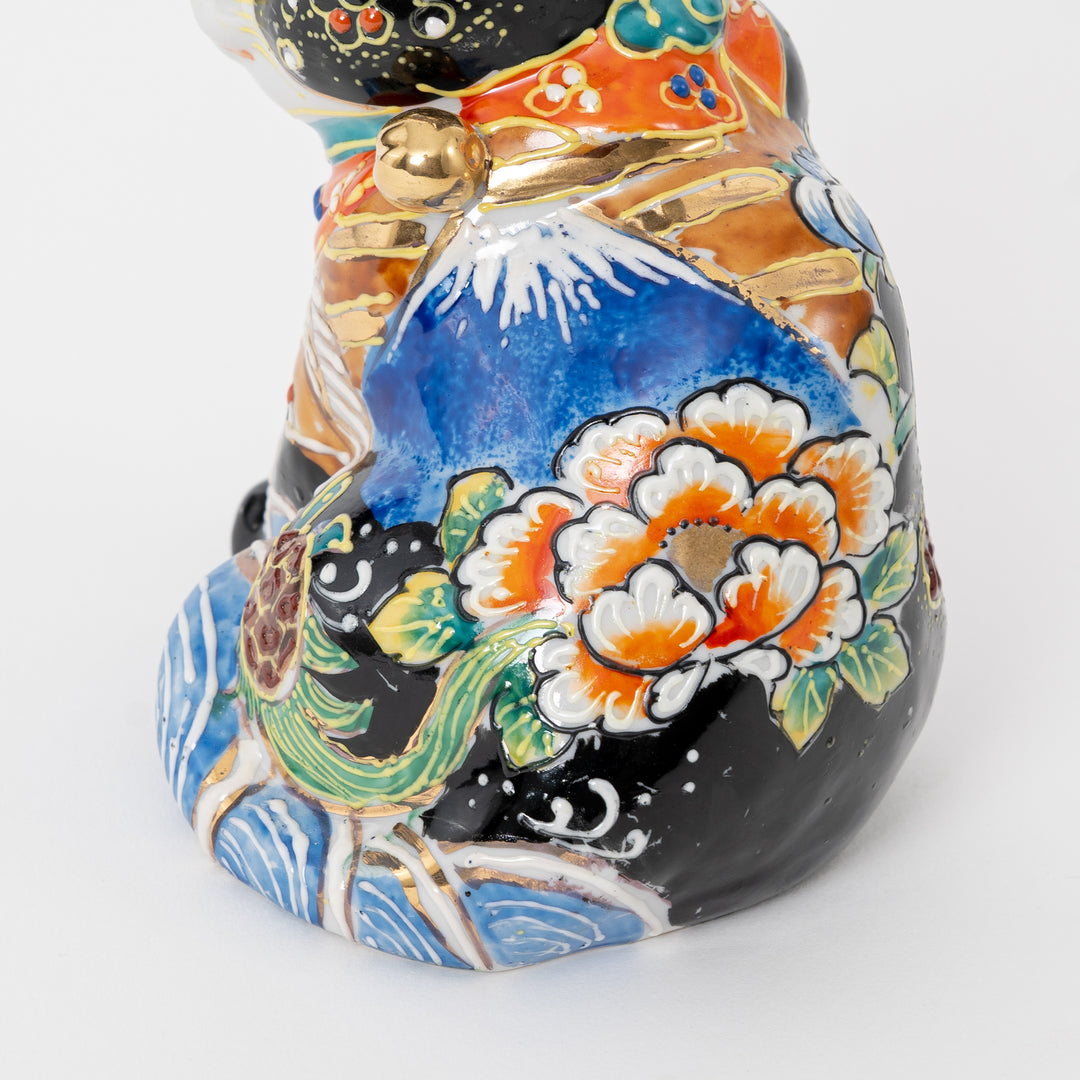 Close-up of the artist's signature (落款) and intricate gold-leaf detailing on a Kutani-yaki Beckoning Cat.