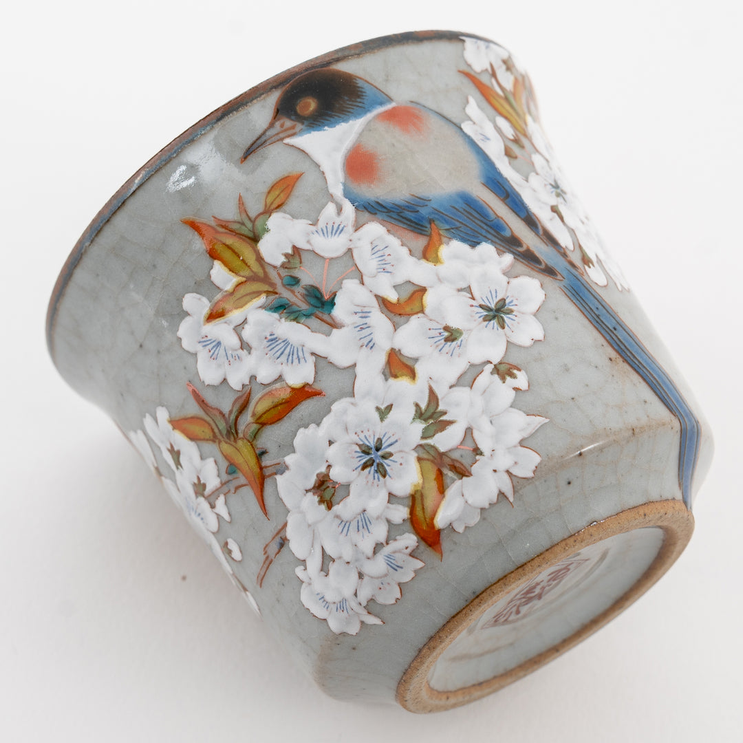 Ceramic mug with bird and floral design on a white background