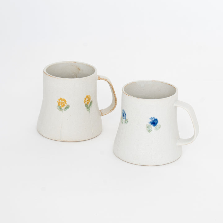Two ceramic mugs with floral designs on a white background