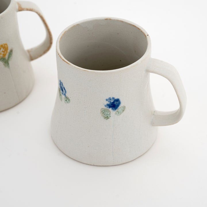 White ceramic mug with floral designs on a white background