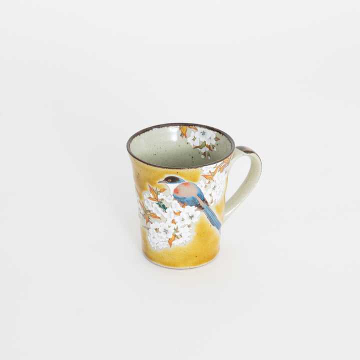 Hand-painted Kutani Yoshidaya mug featuring a bird perched on blossoms with a warm yellow glaze