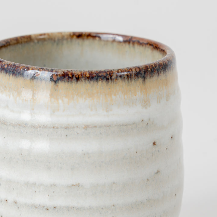Close-up of a ceramic cup with a textured surface on a light background