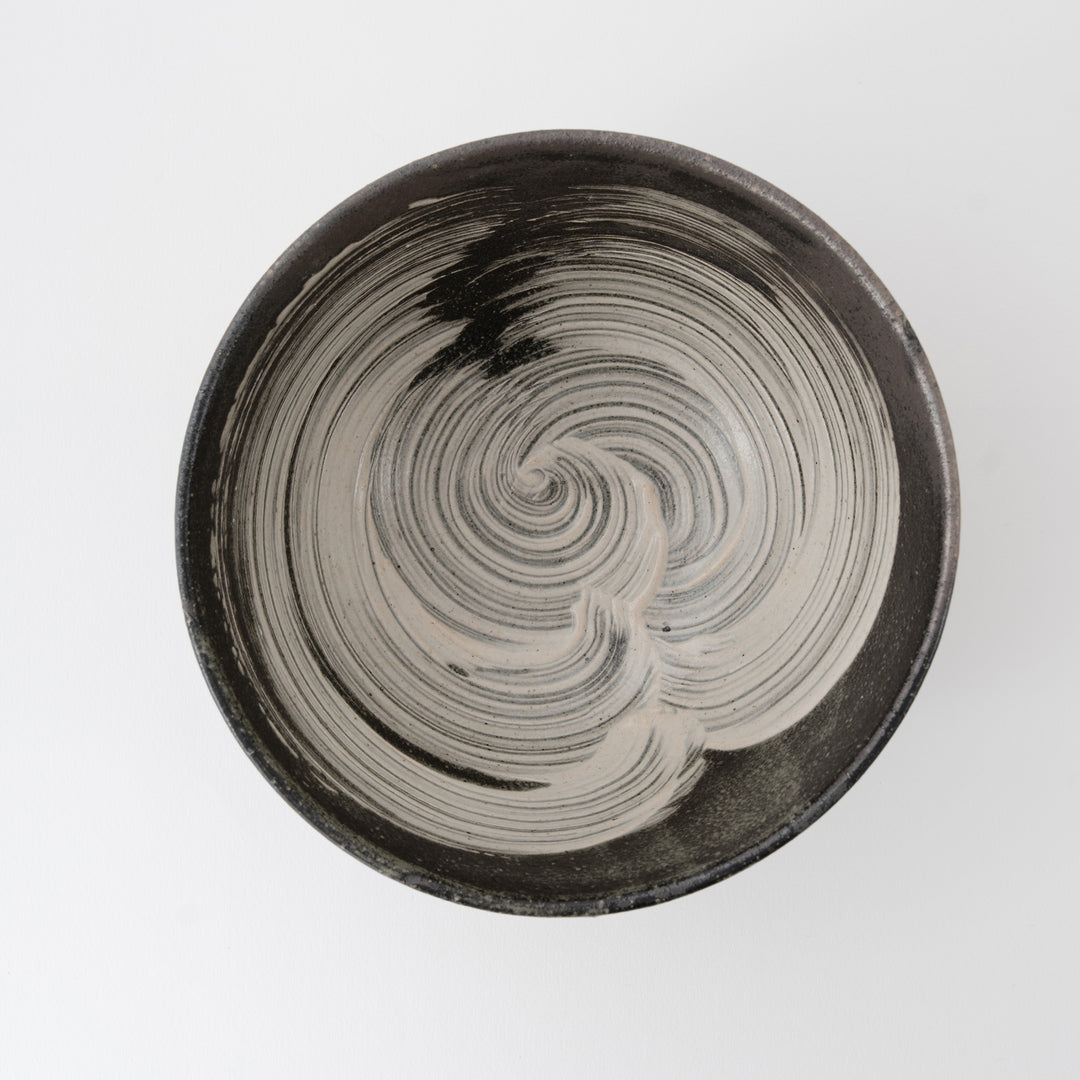 Ceramic bowl with swirling pattern on a light gray background