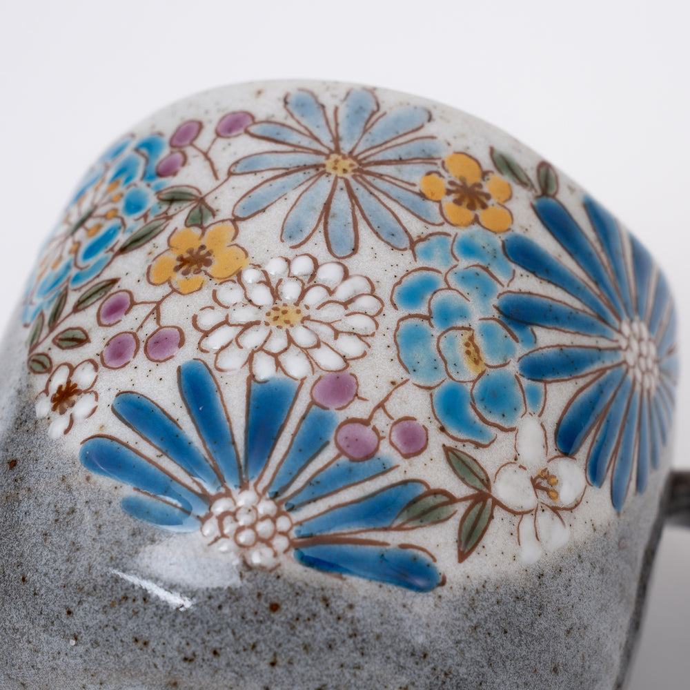 Close-up of intricate hand-painted blue flowers with gold accents on Kutani Ware mug