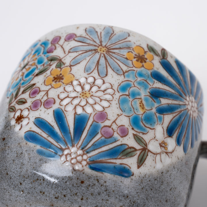 Close-up of intricate hand-painted blue flowers with gold accents on Kutani Ware mug