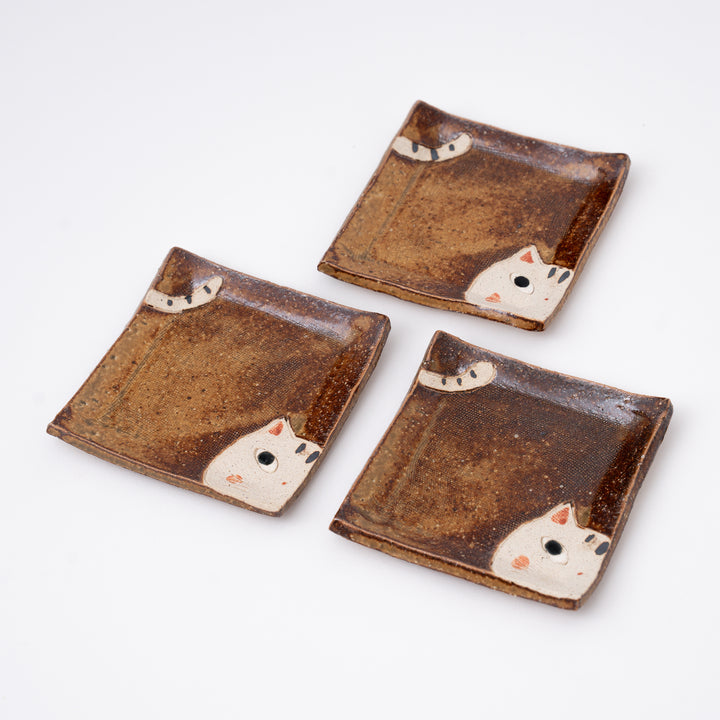 Brown Japanese ceramic mini dish featuring a playful peeking cat