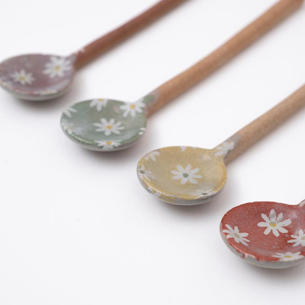 Set of ceramic spoons with floral patterns on a white background