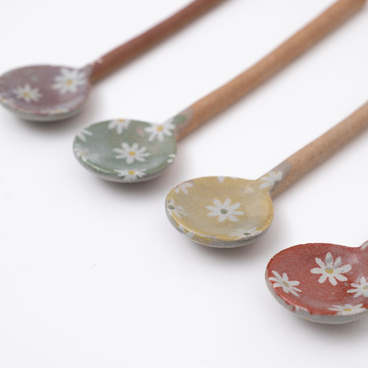 Set of ceramic spoons with floral patterns on a white background