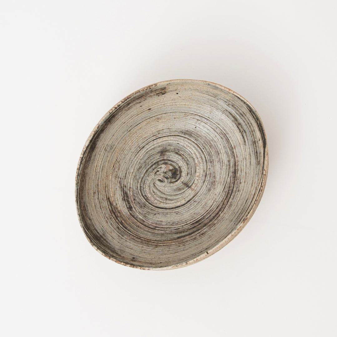 Interior of a Japanese pottery bowl with layered gray, ivory, and brown glaze