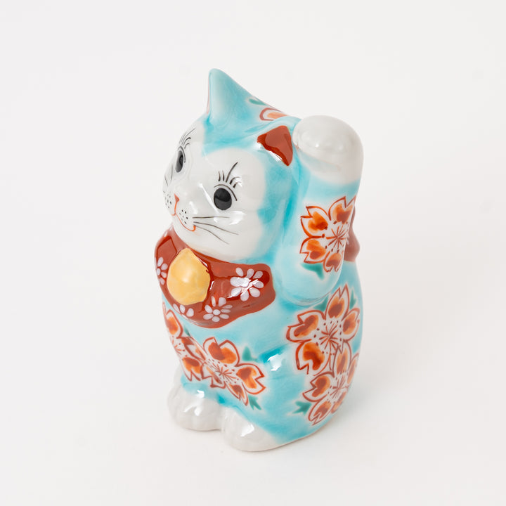 Close-up of the hand-painted blue sakura pattern on an authentic Japanese Kutani Lucky Cat (Maneki Neko).