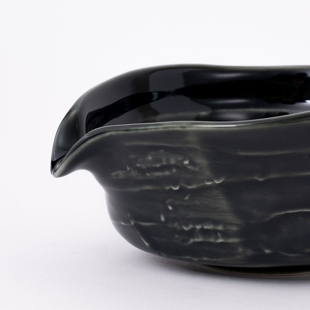 Side view of a handmade Mino Ware Oribe Matcha Bowl showcasing its elegant curved shape and pouring spout.