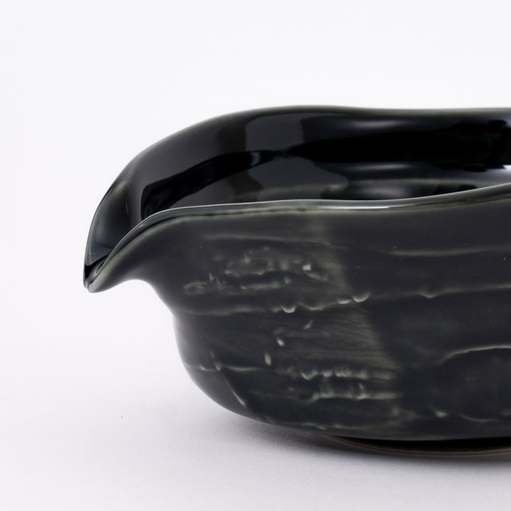 Side view of a handmade Mino Ware Oribe Matcha Bowl showcasing its elegant curved shape and pouring spout.