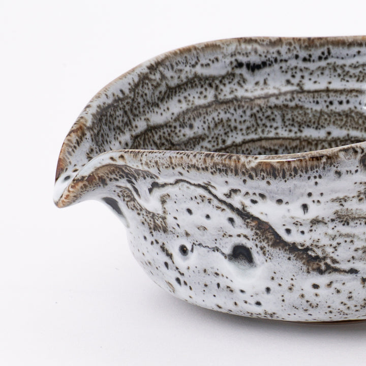 Side view of a handmade Japanese Mino Ware Flowing Glaze Matcha Bowl showcasing its elegant curved shape and pouring spout.