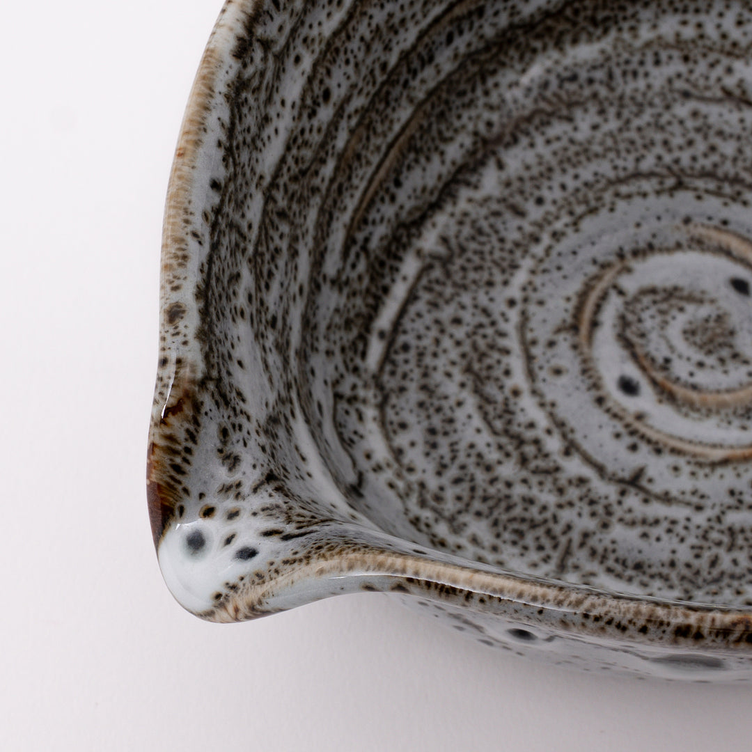 Close-up of the flowing white glaze with natural speckled texture and kiln-fired patterns on a handmade Mino Ware matcha bowl.