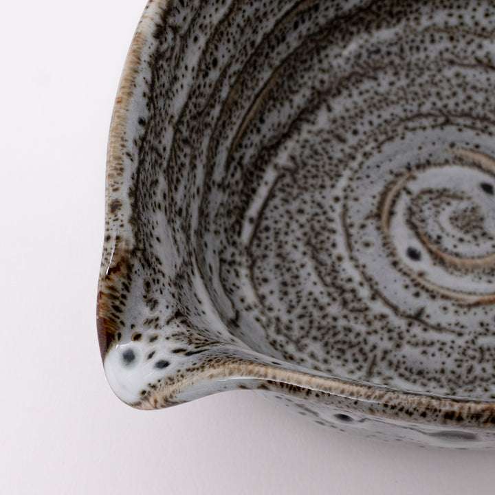 Close-up of the flowing white glaze with natural speckled texture and kiln-fired patterns on a handmade Mino Ware matcha bowl.