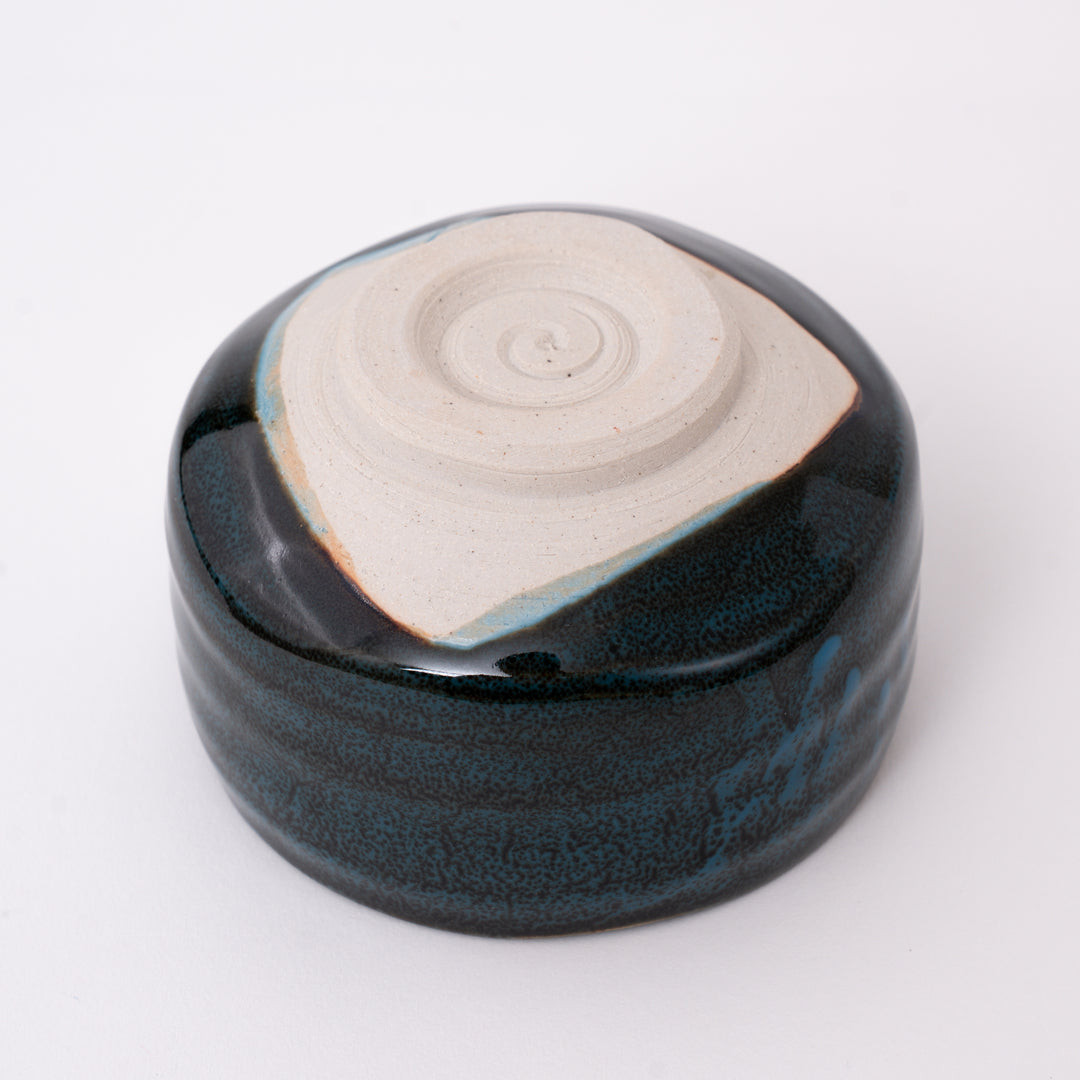 Bottom view of a handmade Japanese Mino Ware ceramic matcha bowl showing the traditional foot ring and maker's mark.