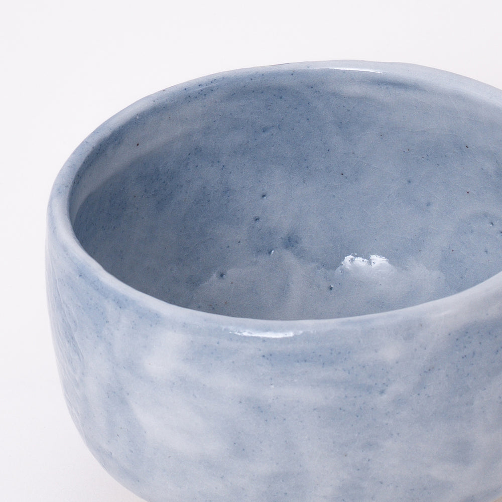 Side view of a handmade Mino Ware Ao Shino Matcha Bowl showcasing its rounded shape and flowing glaze.