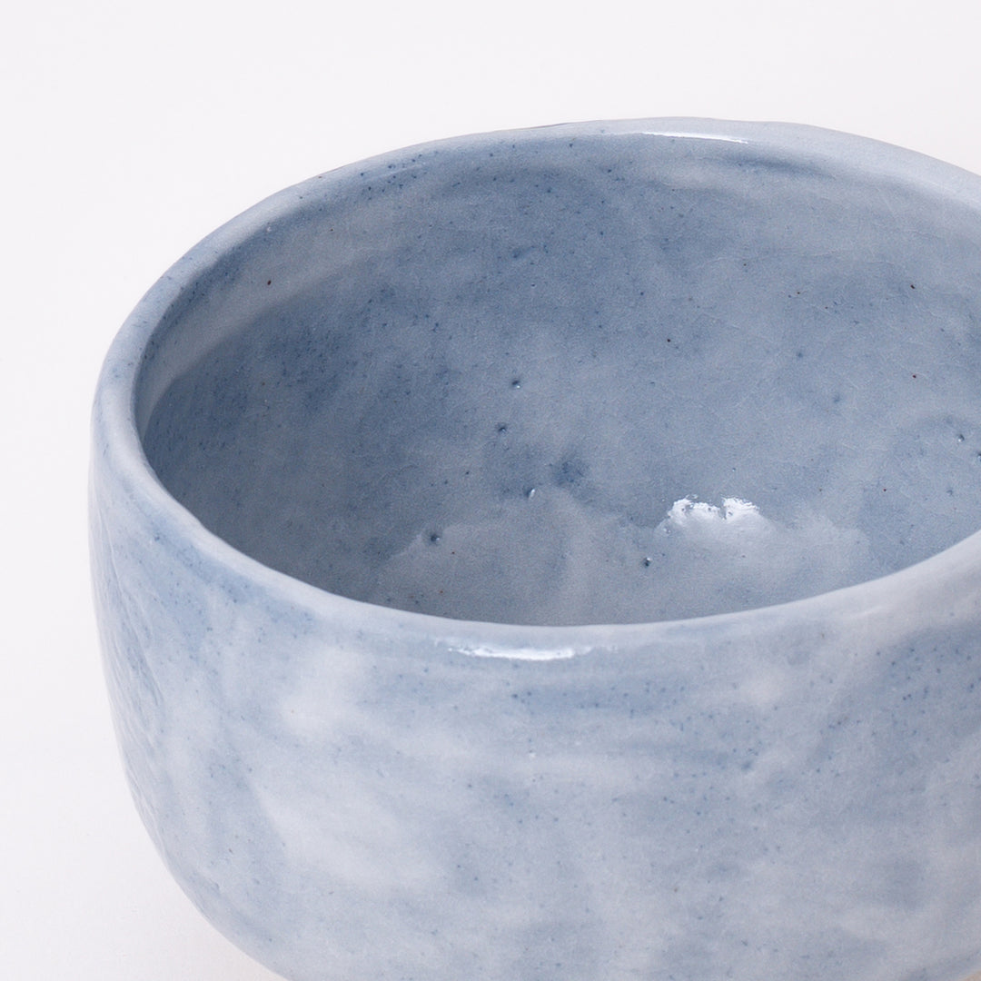 Side view of a handmade Mino Ware Ao Shino Matcha Bowl showcasing its rounded shape and flowing glaze.
