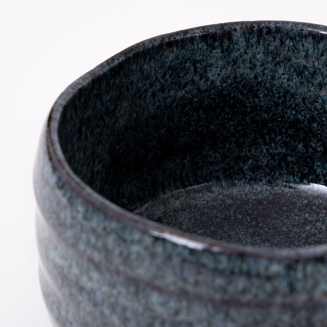Close-up of the flowing blue ash glaze with natural kiln-fired variations on a handcrafted Mino Ware matcha bowl.