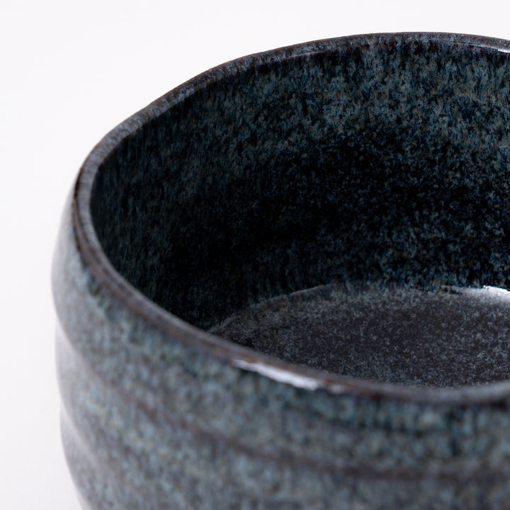 Close-up of the flowing blue ash glaze with natural kiln-fired variations on a handcrafted Mino Ware matcha bowl.