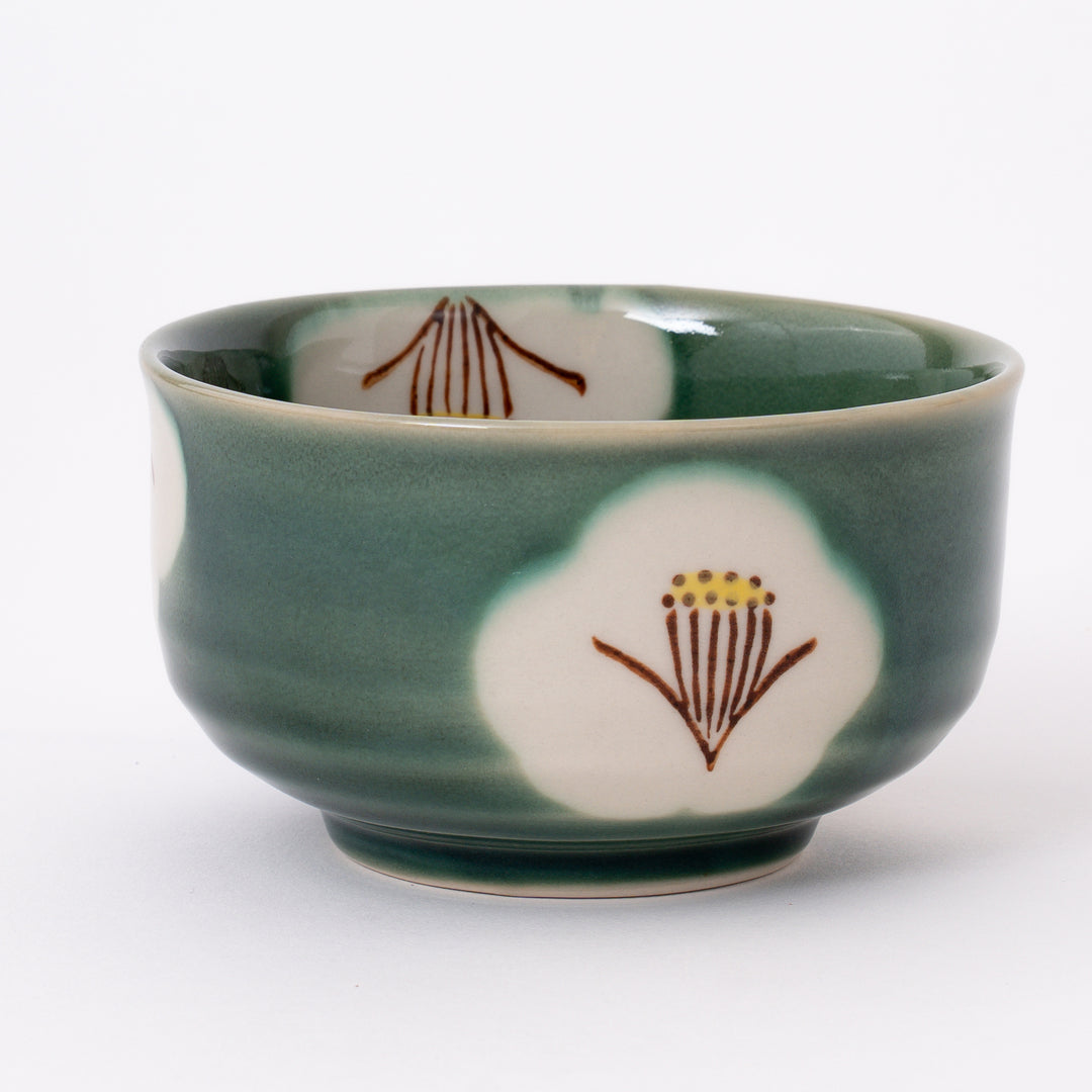 Side view of a handmade Seto Ware ceramic matcha bowl showcasing its Oribe green glaze and rounded shape.