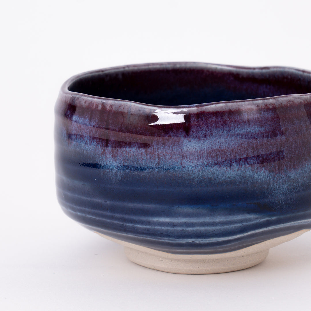Close-up of the flowing purple and indigo glaze with natural kiln-fired variations on a handcrafted Mino Ware matcha bowl.