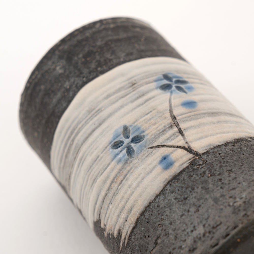 Close-up detail of blue floral Shigaraki mini vase with charcoal pottery texture